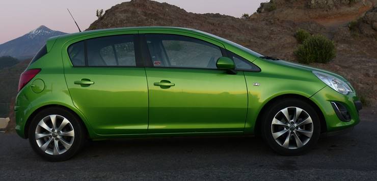 Zeleni automobil Opel Corsa parkiran na proplanku 